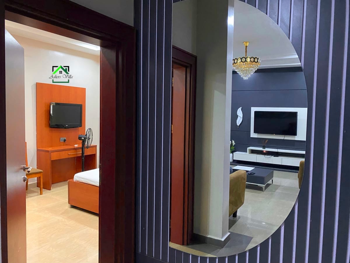 Asher's Villa Abuja - Stylish lounge area with modern furniture and entertainment system